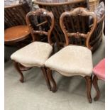 A pair of Victorian mahogany balloon back dining chairs with light brown patterned seats