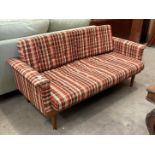 A mid Twentieth Century teak framed bed settee with brown/red and ivory patterned upholstery -