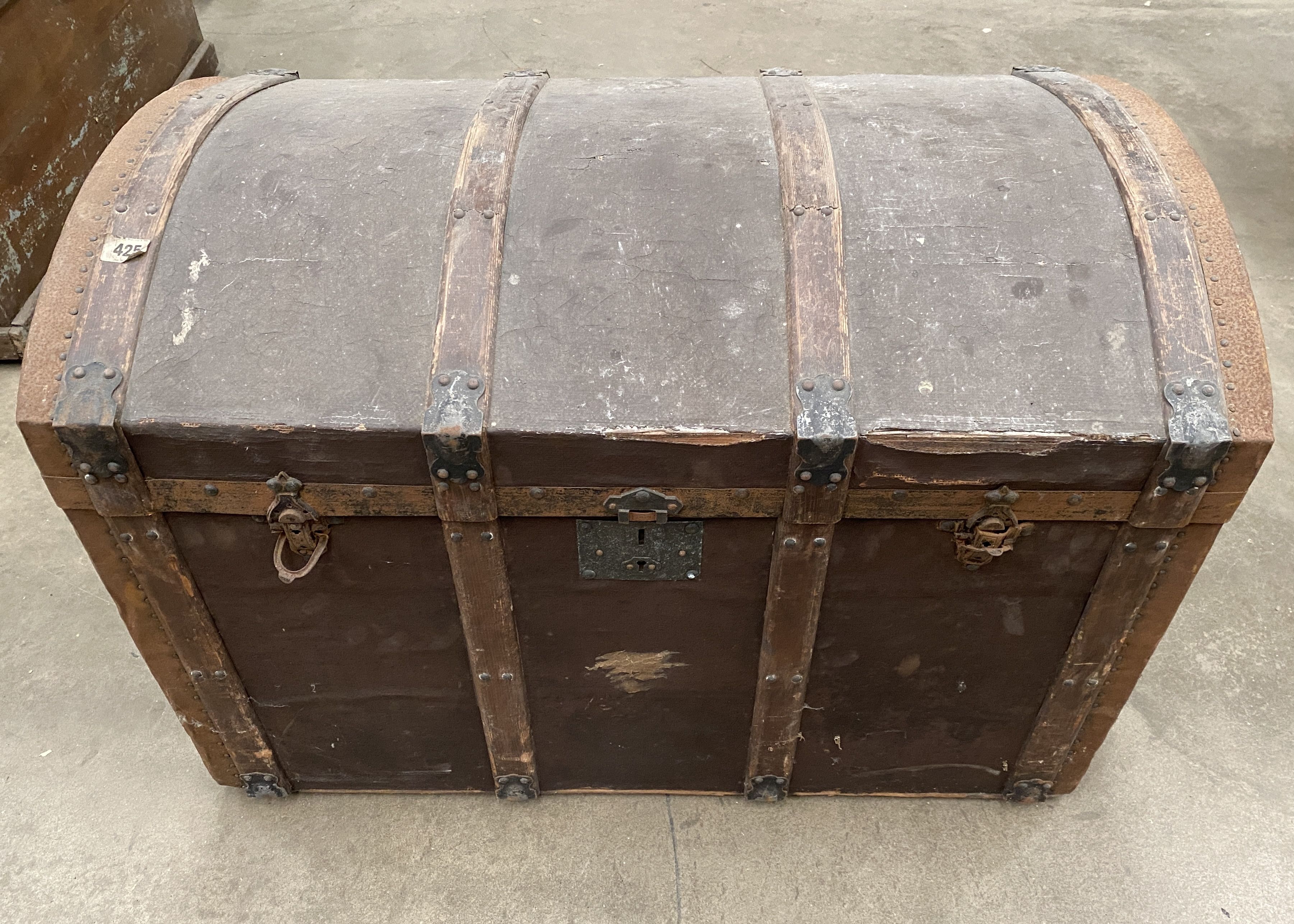 A wood framed brown fibre upholstered dome top trunk,