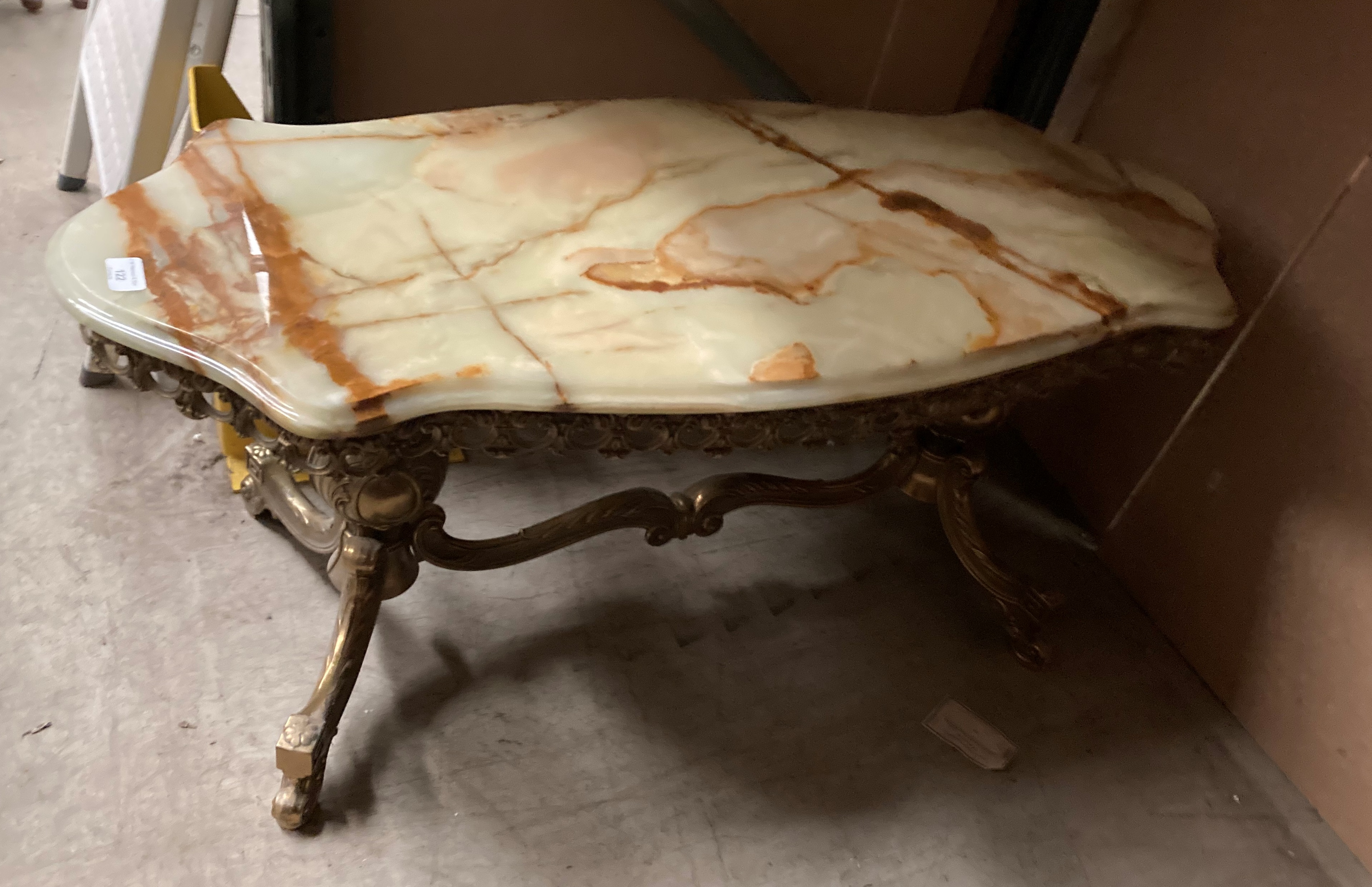 A brass framed coffee table with green and brown marble shaped top 108cm x 44cm