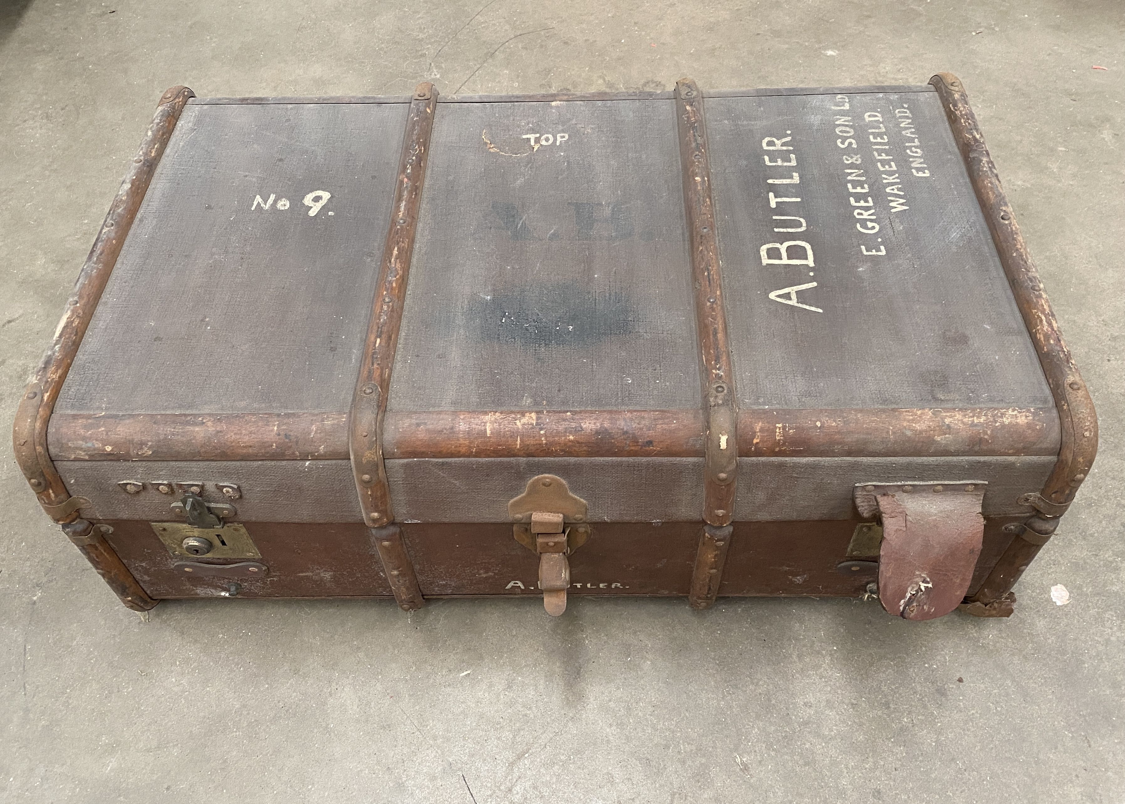 A wood framed brown fibre upholstered trunk initialled A Butler,