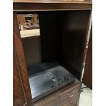 A large mahogany finish entertainment cabinet with two upper doors over two drawers,