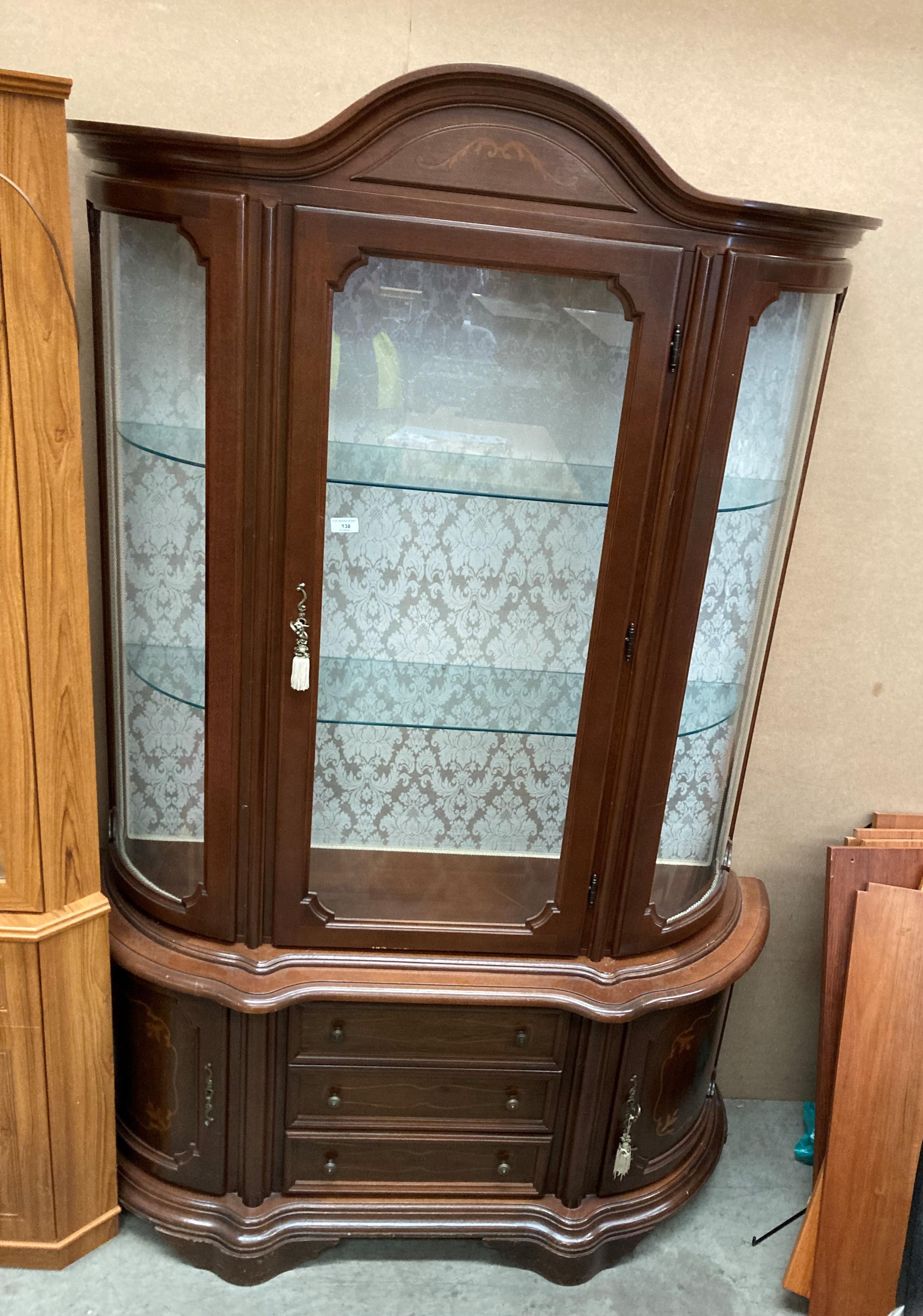 A mahogany bow front display cabinet with single door and two glazed shelves over three drawer two