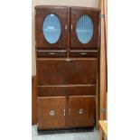 A Shefco dark stained wood utility kitchen cabinet featuring drop down white enamel work surface