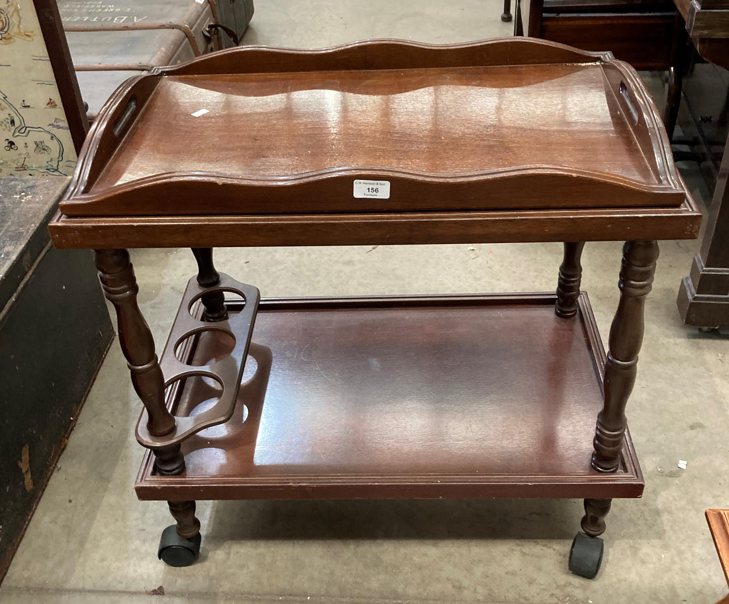 A mahogany mobile two tier drinks trolley with lift out Butlers tray