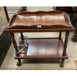A mahogany mobile two tier drinks trolley with lift out Butlers tray