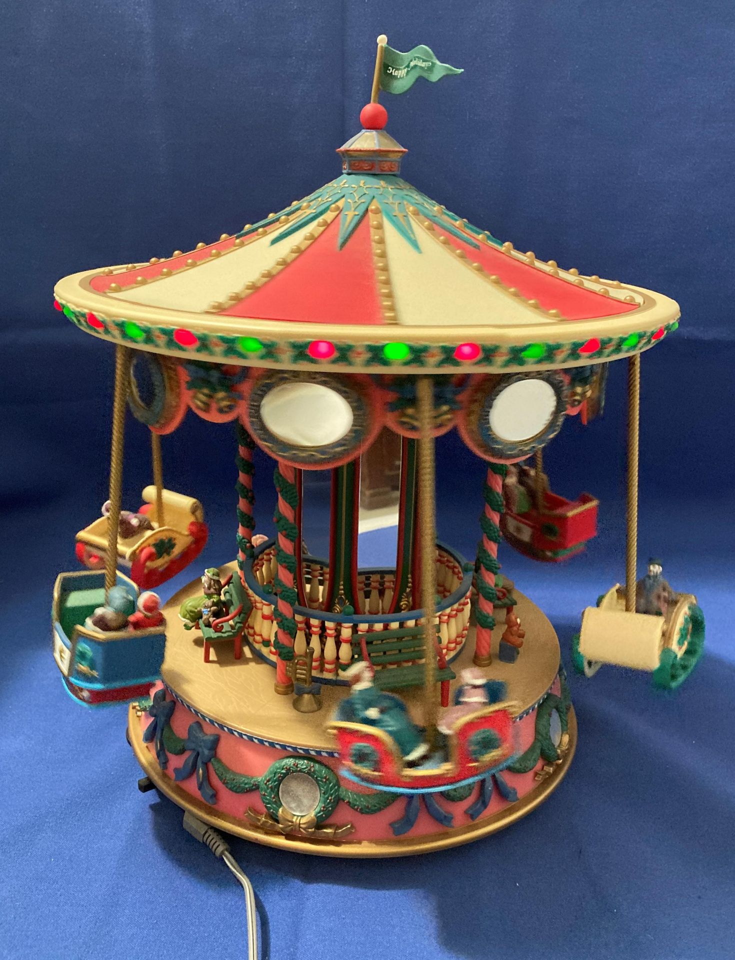 Holiday Fair Merry-Go Round with six chariots and passengers that spin up and out and around in a