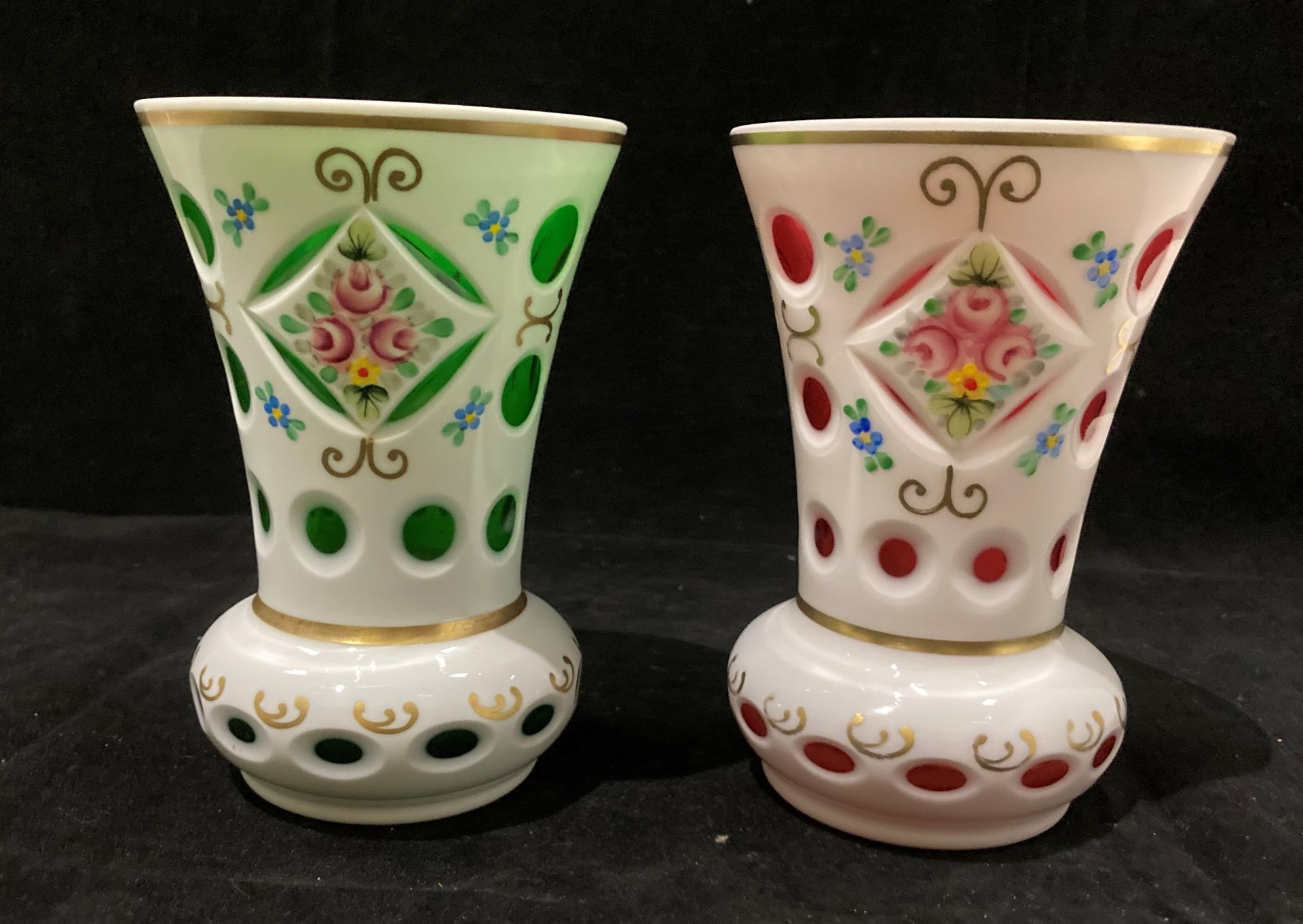 Two white patterned vases, one with green and one with pink glass liners each 14cm high.