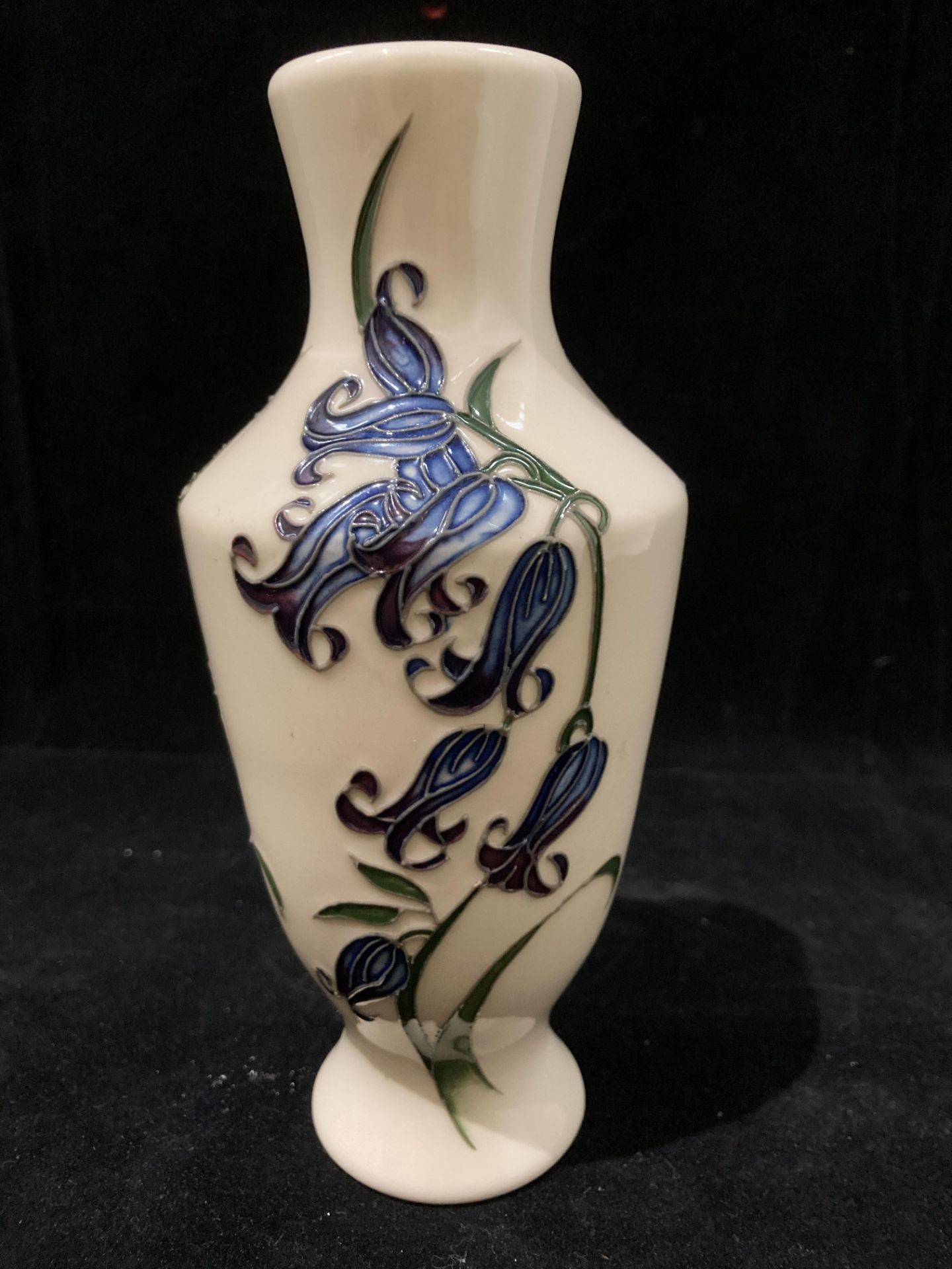 A Moorcroft cream and blue floral glazed vase 16cm high, signed 'HD 2009' to base.