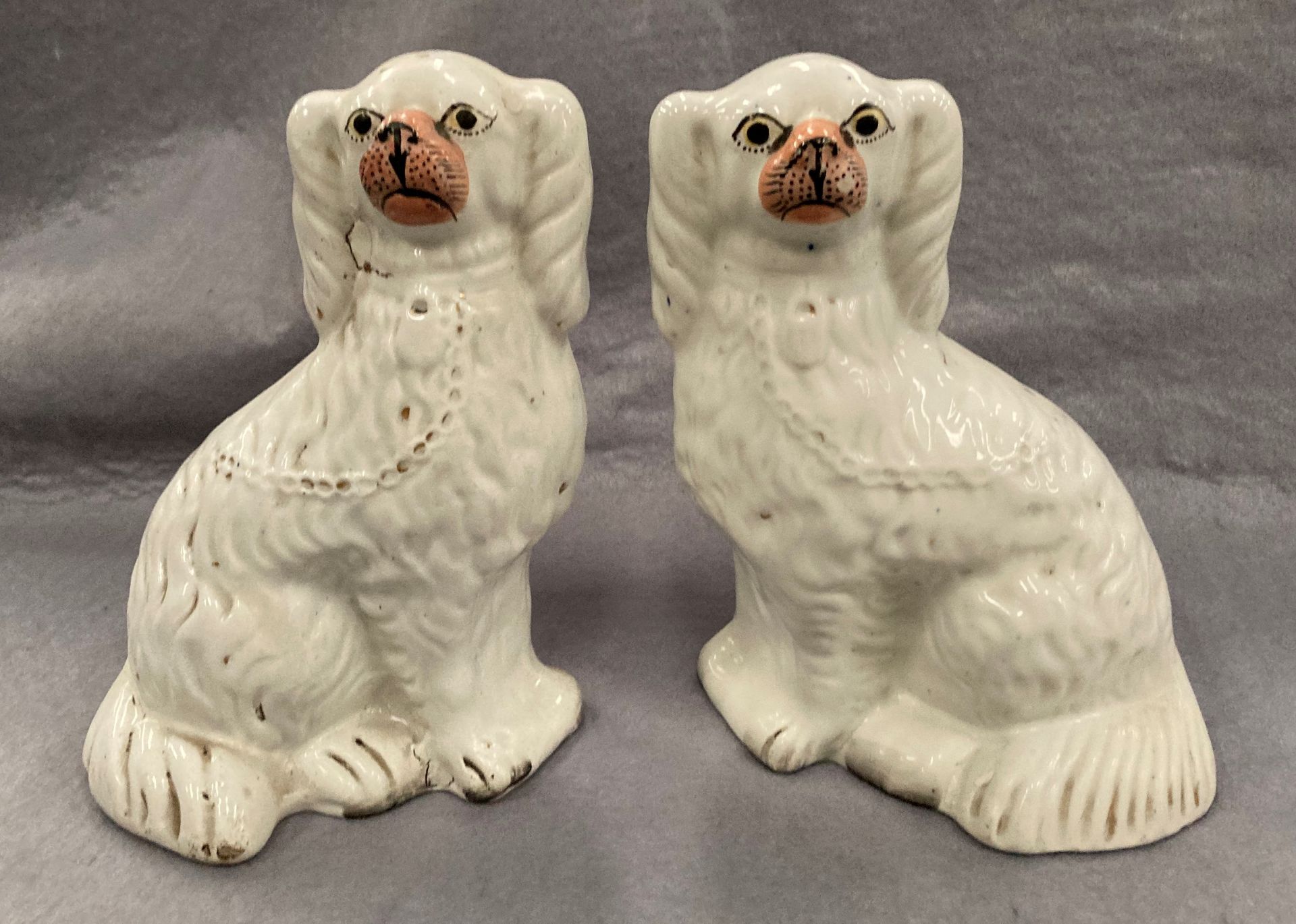 A pair of Staffordshire seated pottery Spaniels,