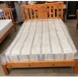 A pine double bed 4'6" complete with brown striped mattress