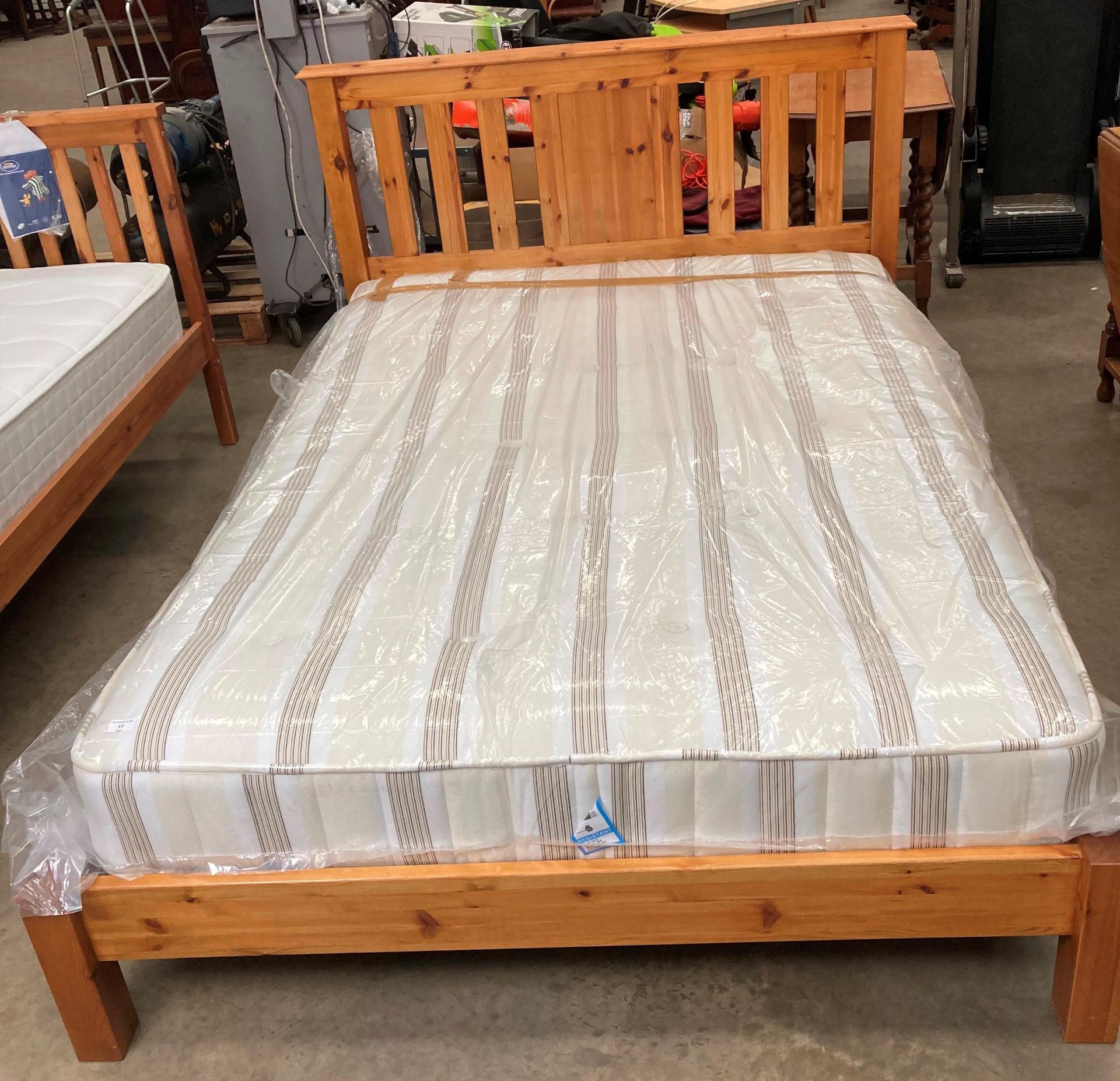 A pine double bed 4'6" complete with brown striped mattress