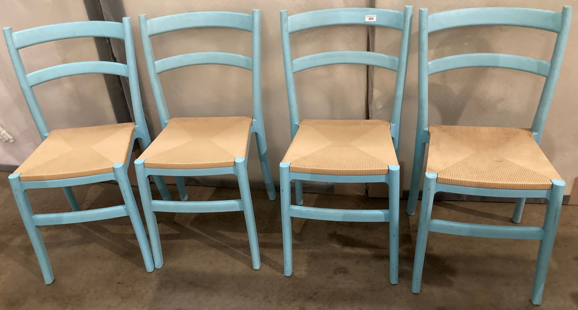 Five blue plastic dining chairs with brown plastic seats and two pink wooden dining chairs