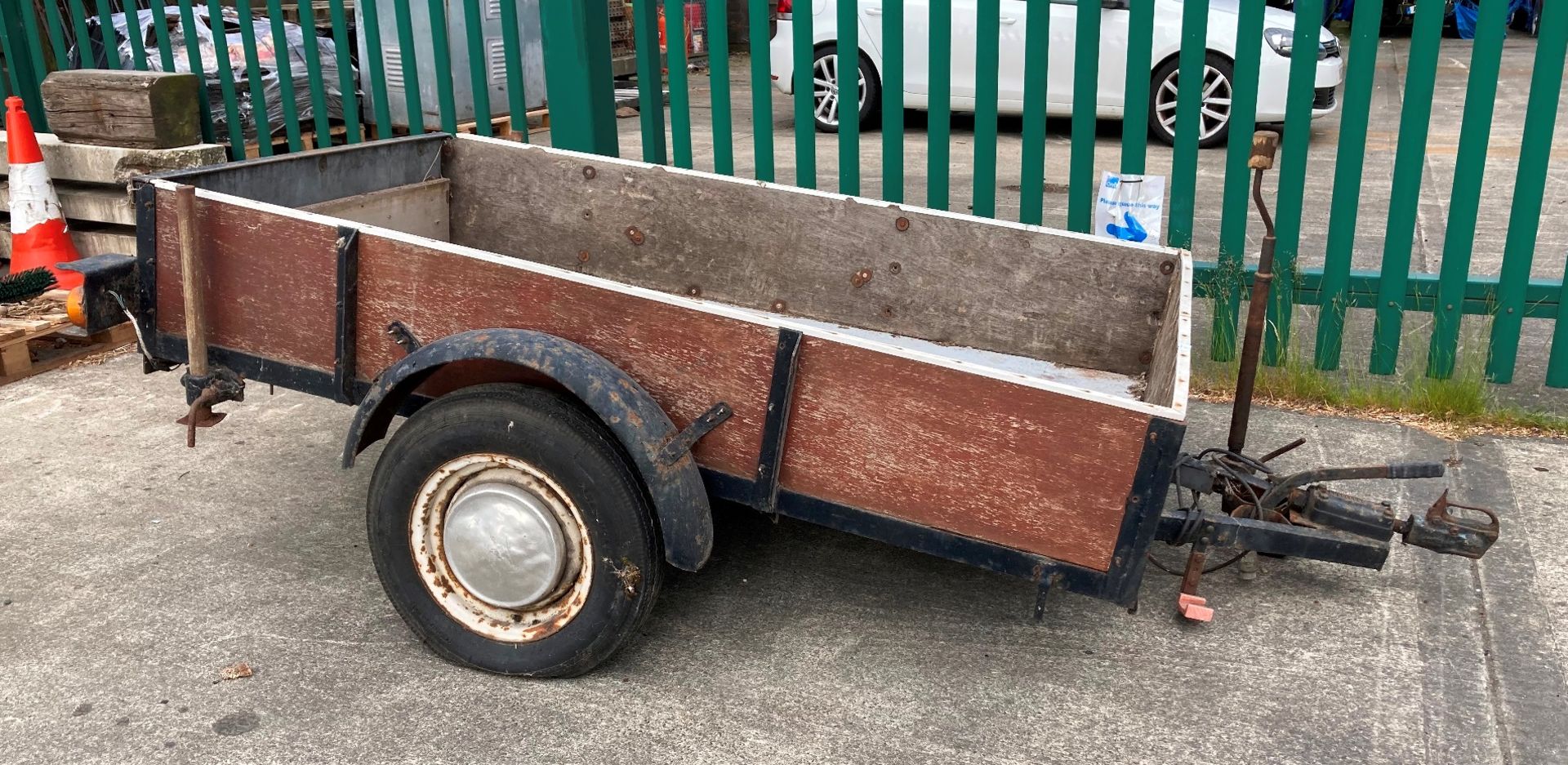 A metal framed single axle trailer with wood sides, 120cm x 200cm x 34cm deep - rusty condition,