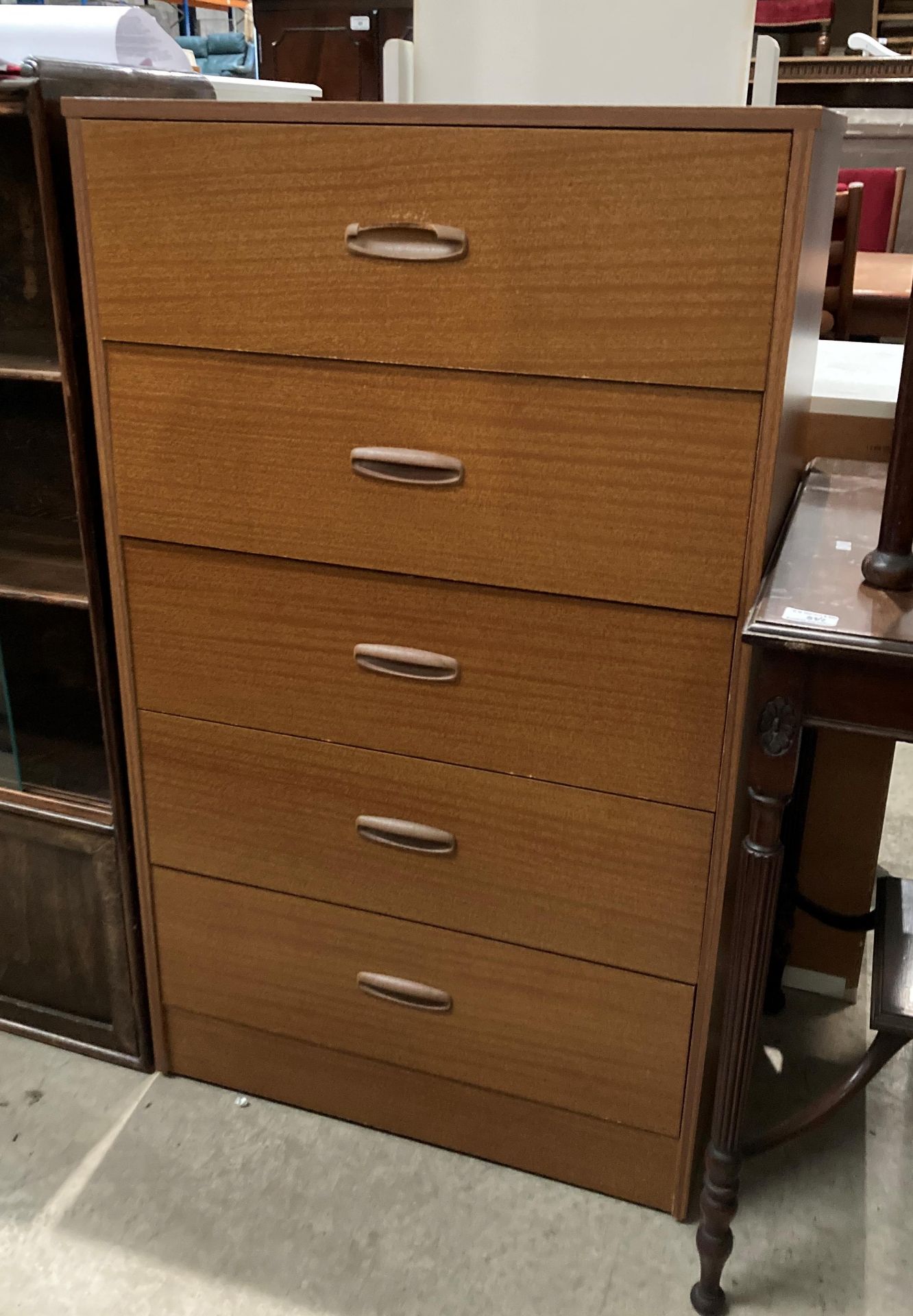 A teak finish five drawer chest of drawers,