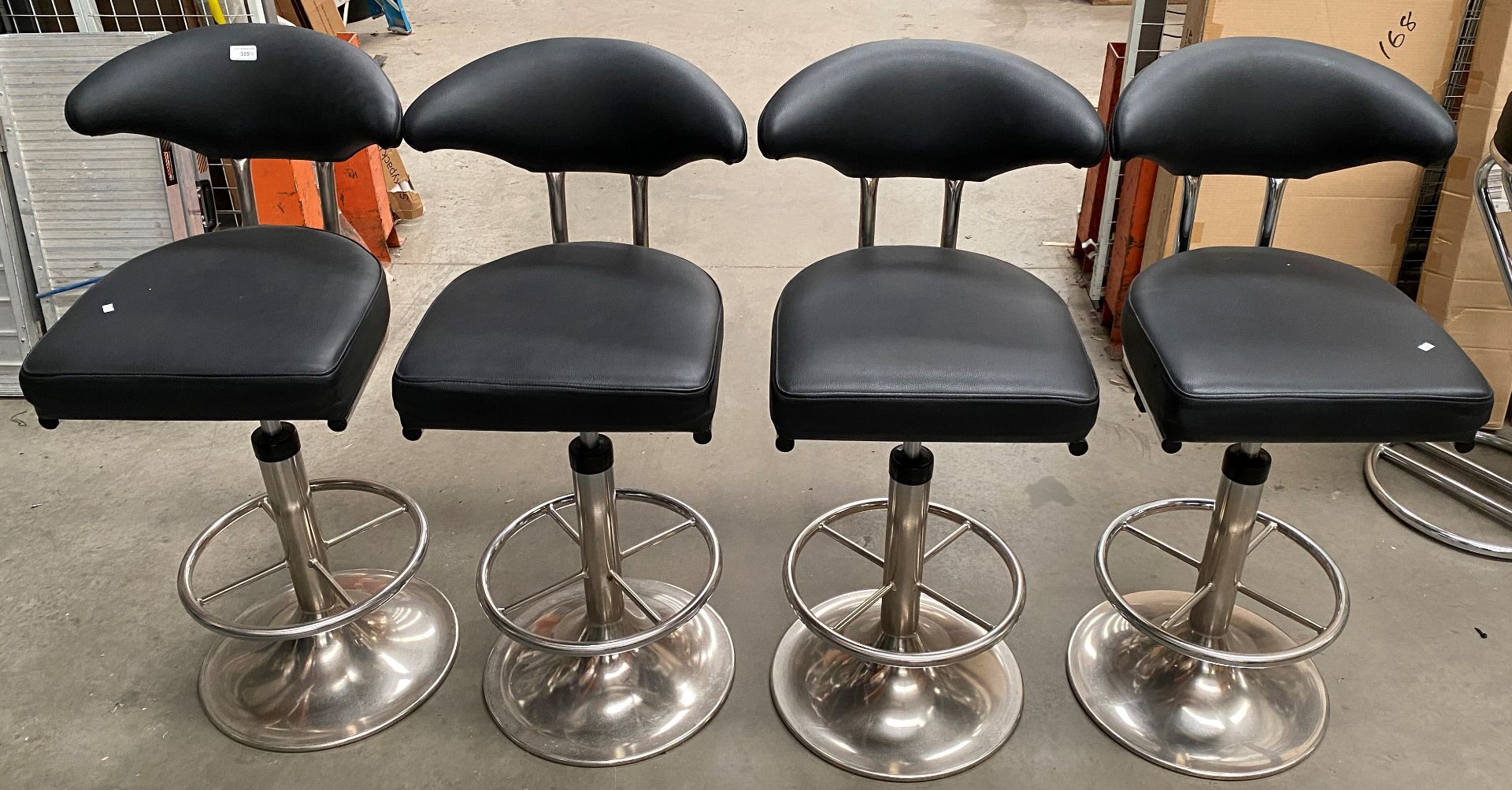 A set of four chrome framed black vinyl upholstered high bar stools (MS) (Vatable Lot)