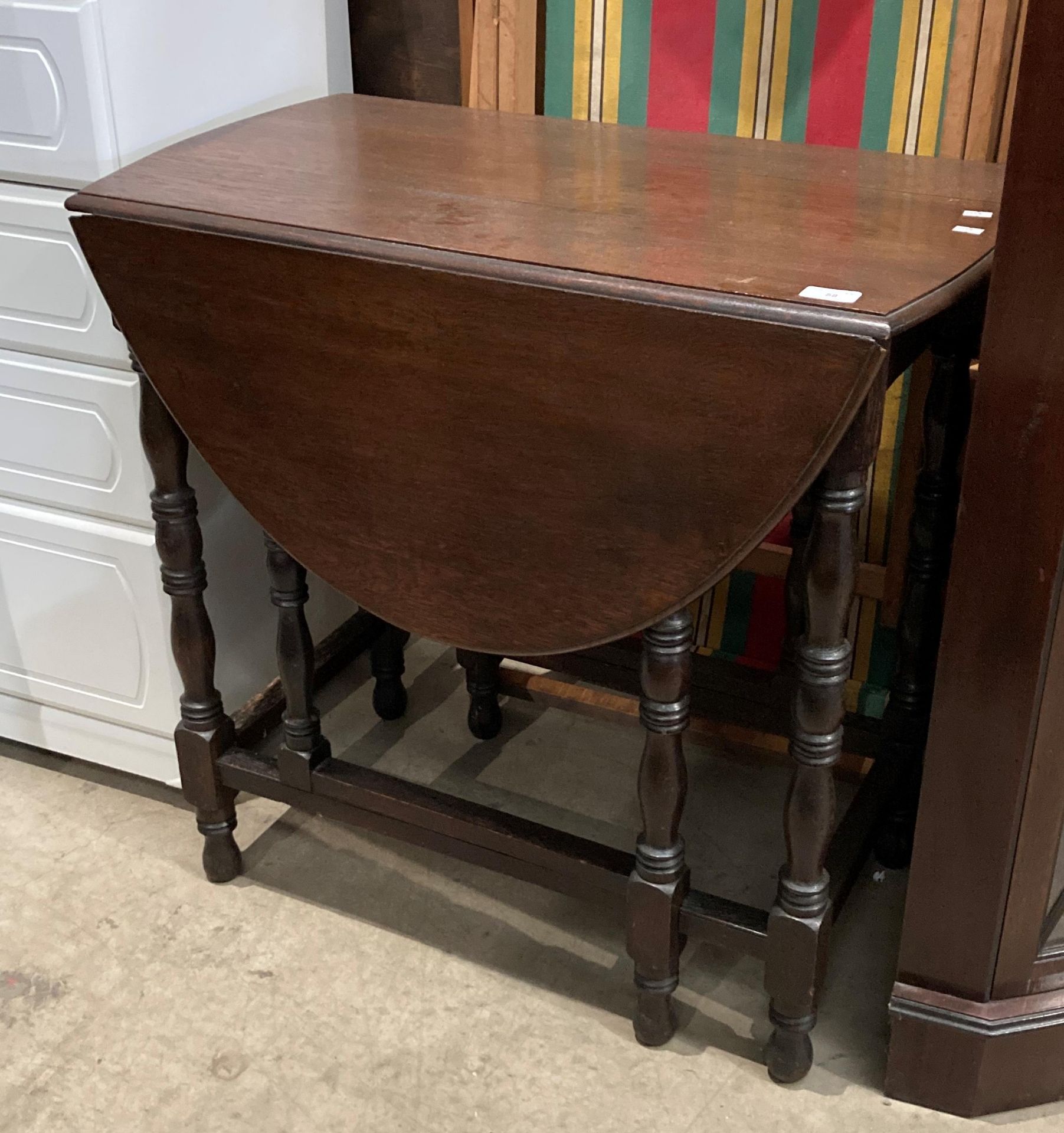 An oak drop leaf gate leg oval side table,