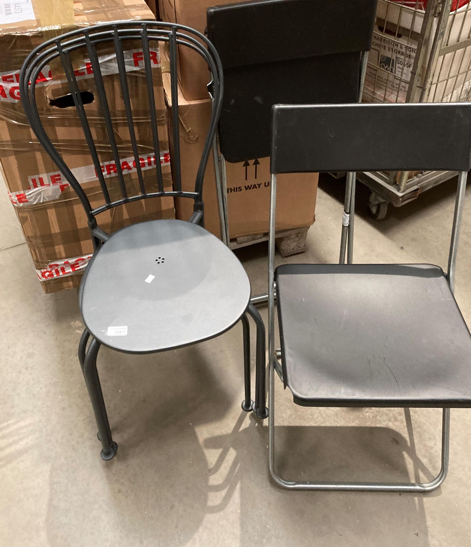 Three Ikea black metal framed canteen chairs and two Ikea metal framed and plastic folding chairs