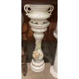 A continental style cream floral decorated jardiniere stand with pottery urn planter on top,