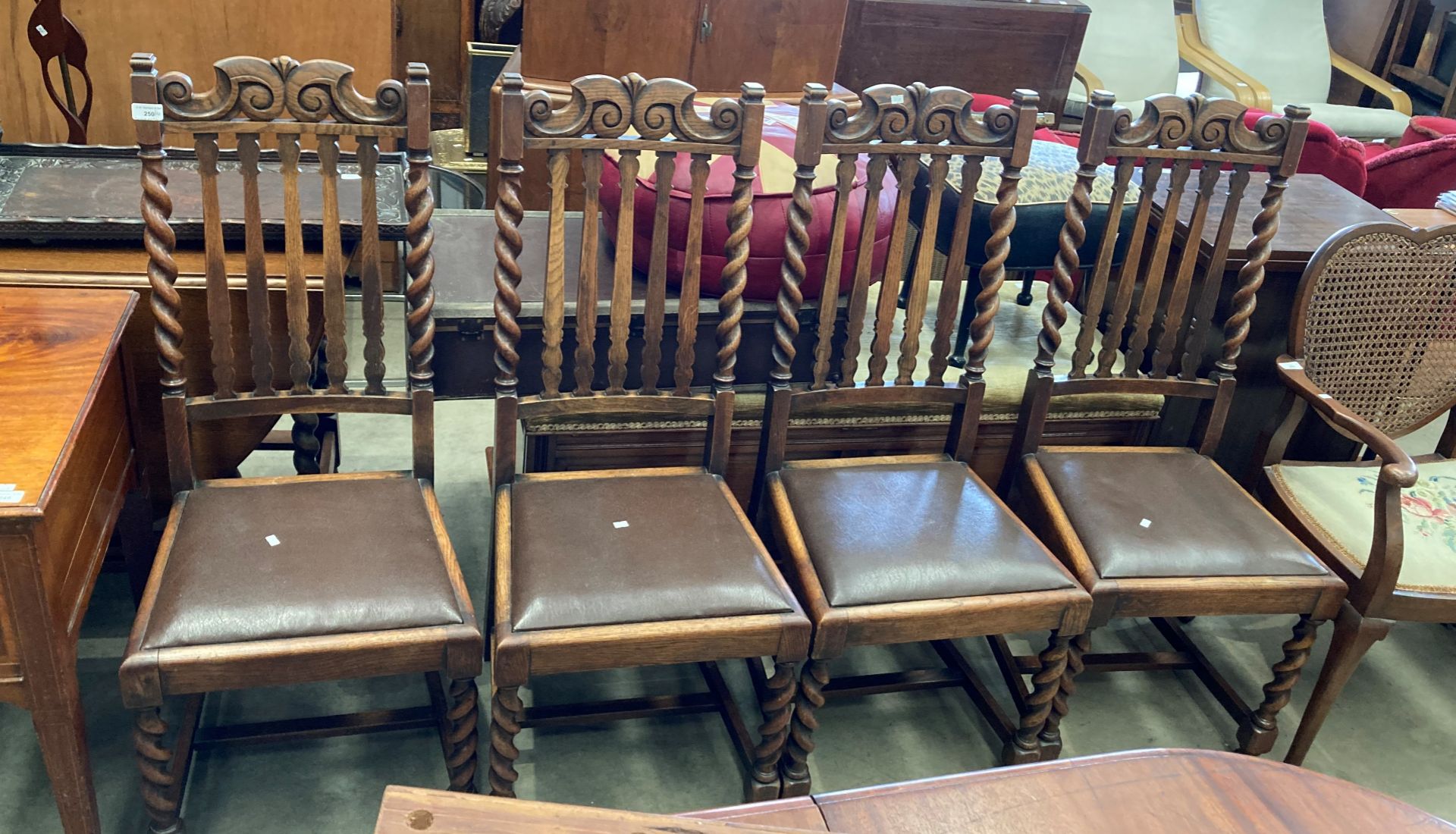 A set of four oak dining chairs with barley-twist columns and legs,