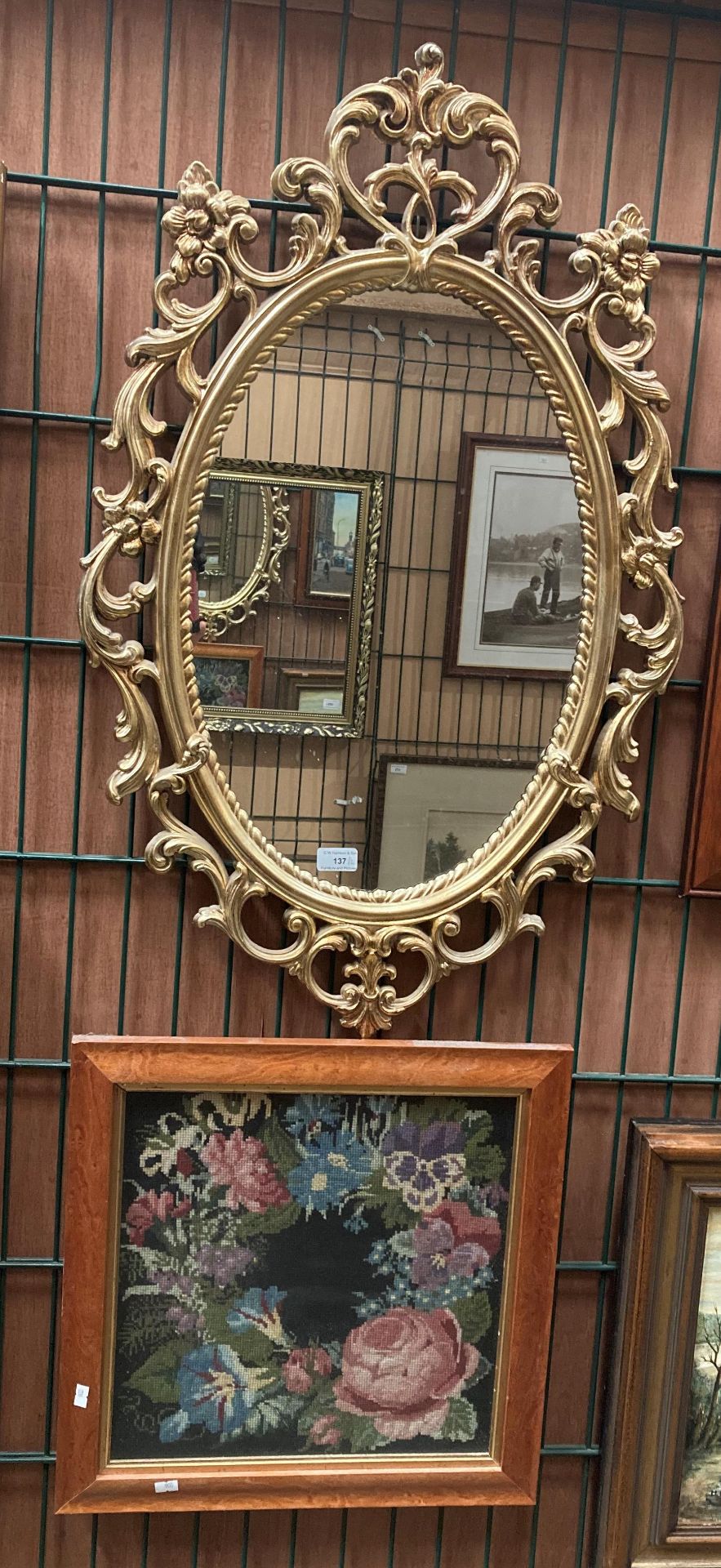 Ornate gilt framed wall mirror, 90cm x 56cm and a small framed tapestry picture of flowers,