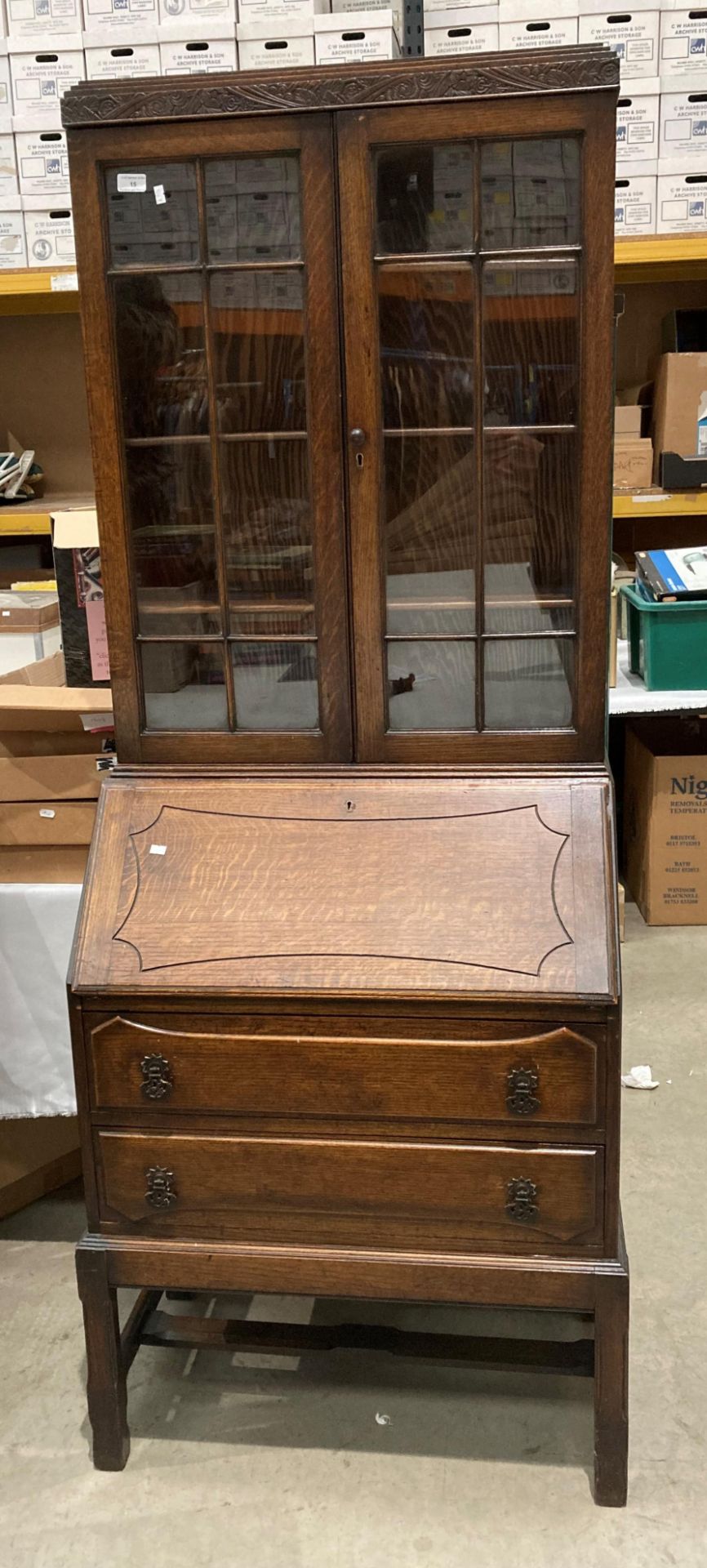 An oak bureau bookcase with two wood lined glazed doors over fall flap two drawer base,