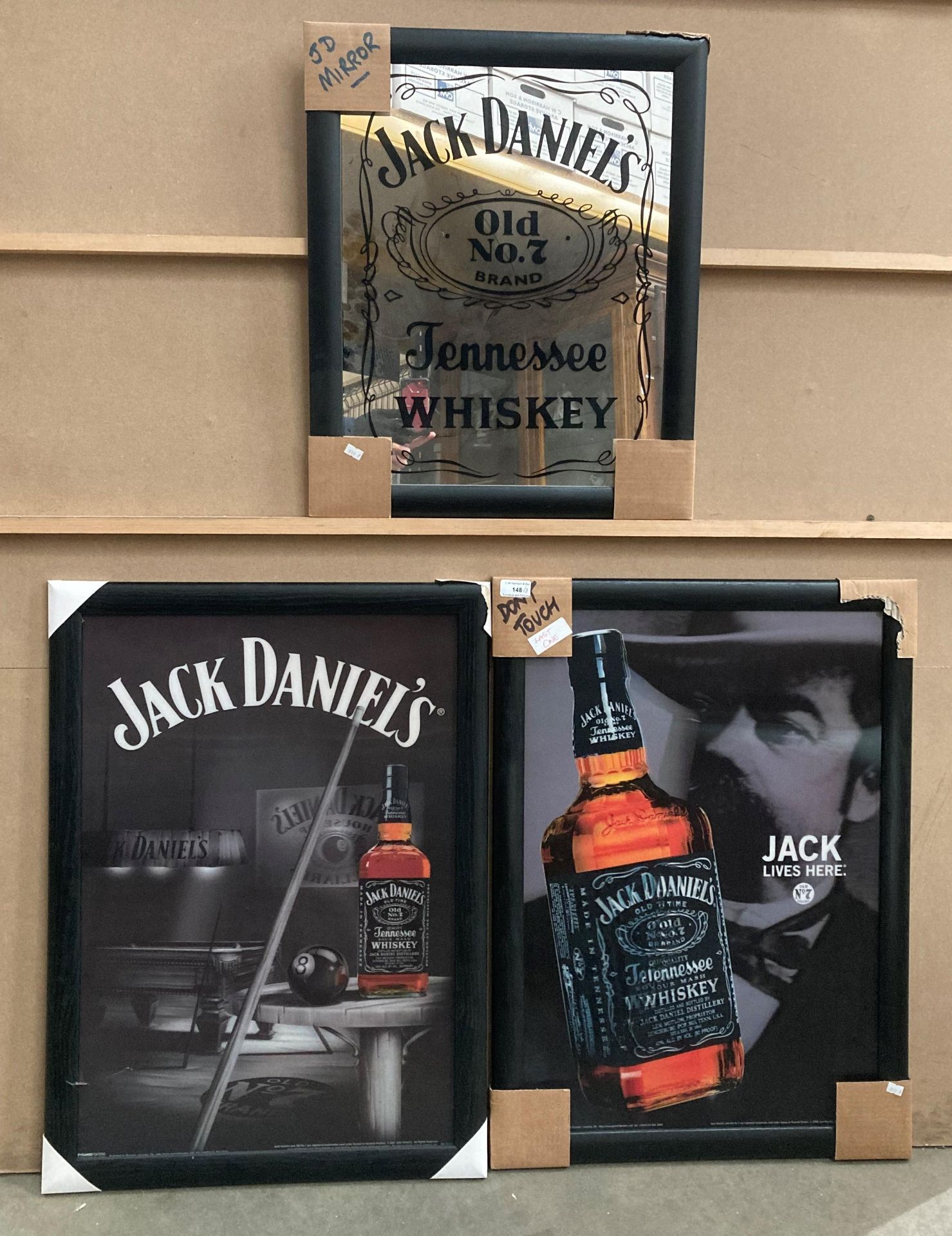 Two framed Jack Daniels prints, each 70cm x 46cm and a Jack Daniels reproduction wall mirror,