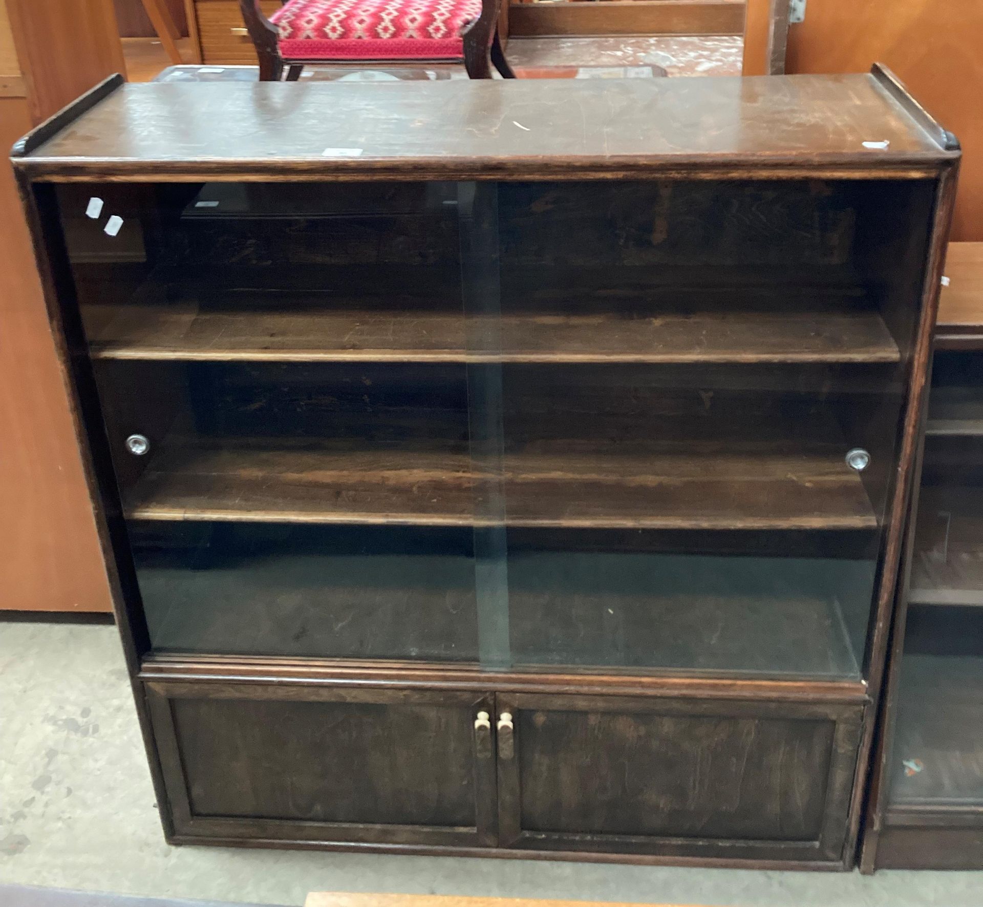 An oak finish bookcase/display cabinet with two glass sliding doors over two door base 100cm x