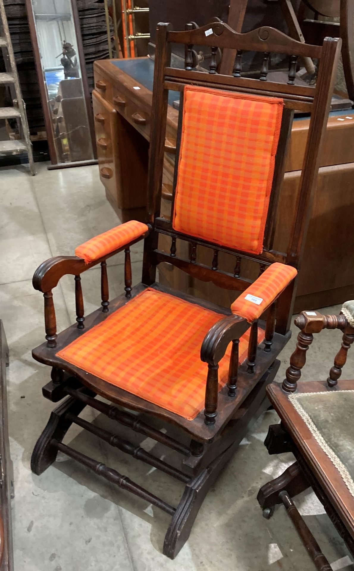 A stained wood American rocking chair with orange fabric upholstery (MS)
