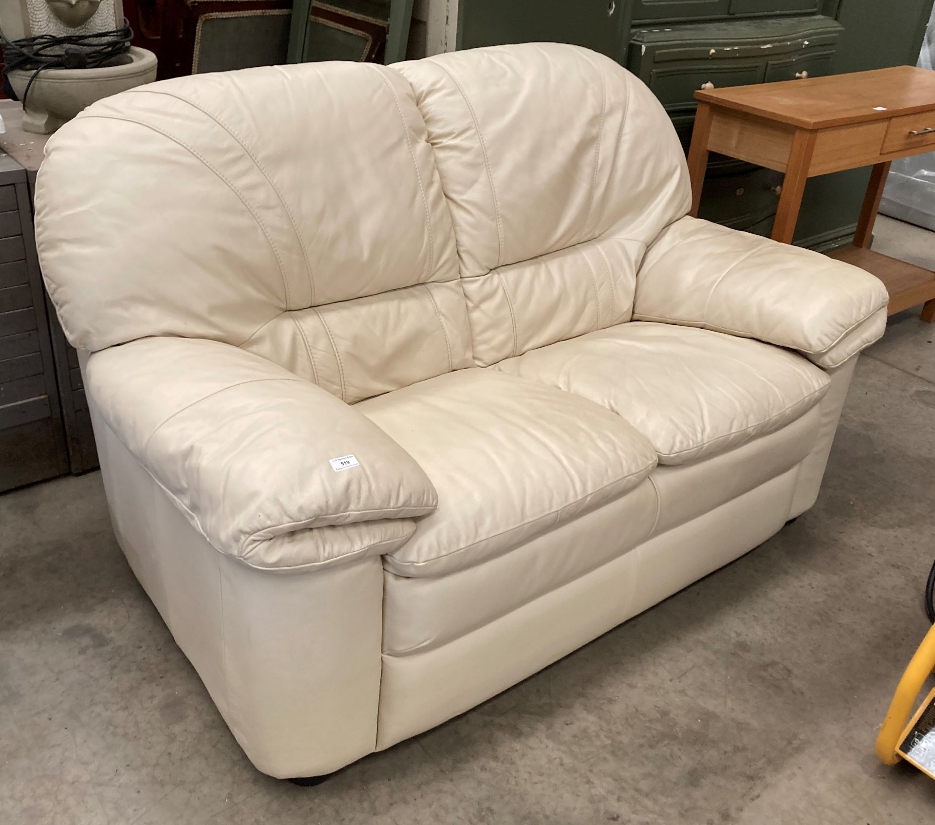 A beige leather two seater settee (MS)