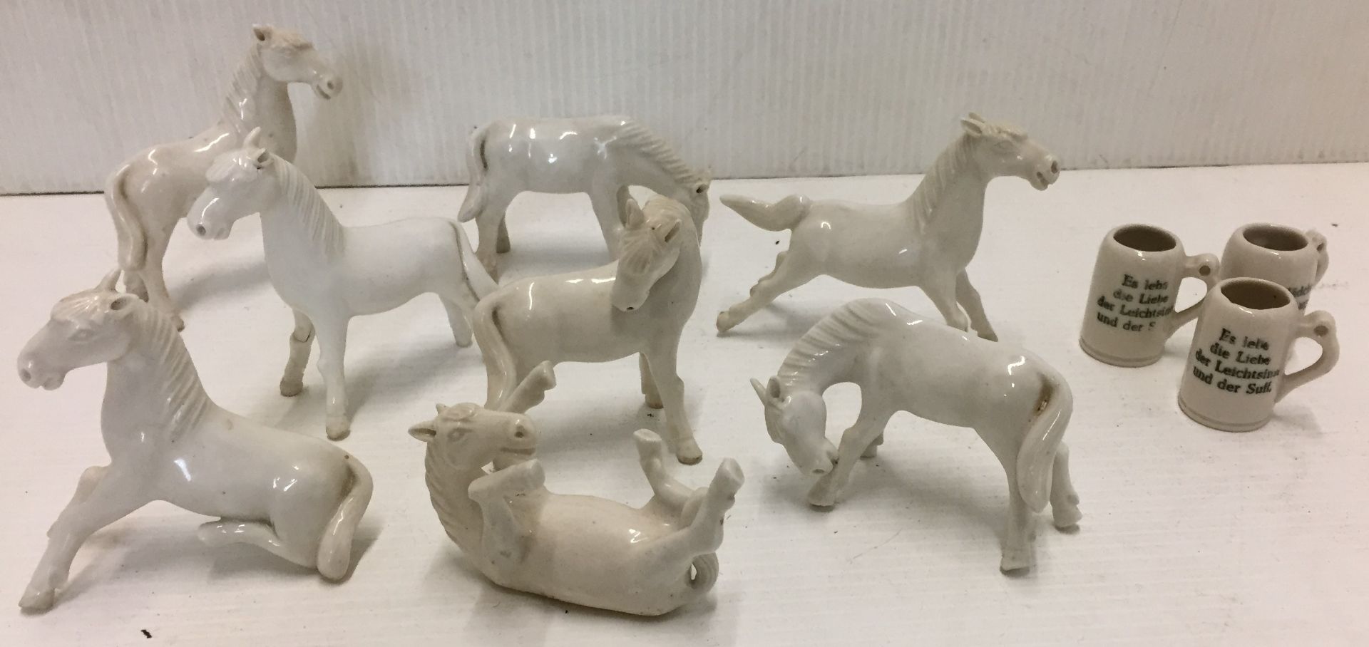 Eleven items including eight white horses max height 8cm and three miniature steins 3.