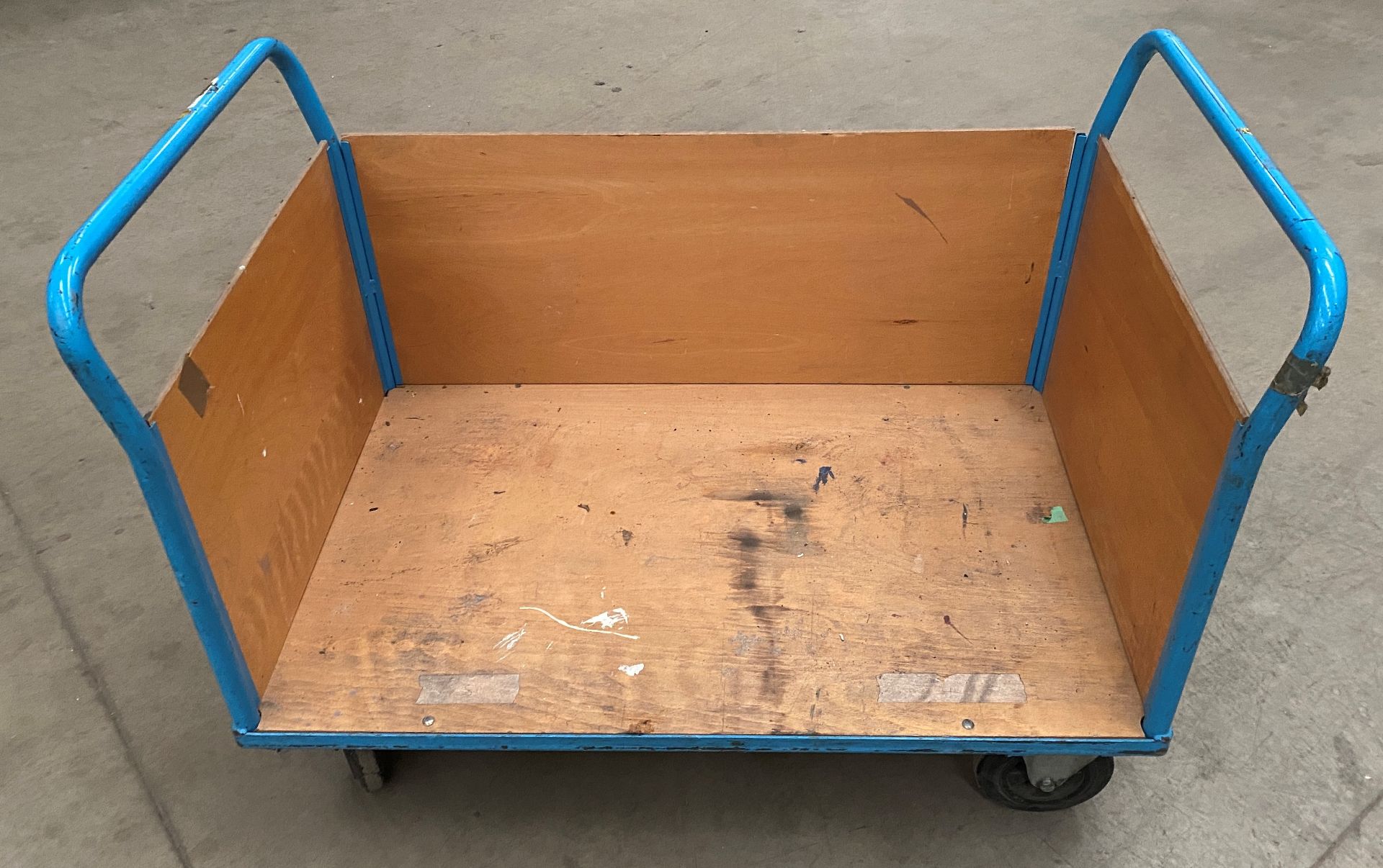 A blue metal framed 4 wheel doubled ended mobile stock trolley with a side side panel