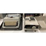 A Scheidegger Typomatic TM manual typewriter in case and a Aldis Projector (flex cut off - not