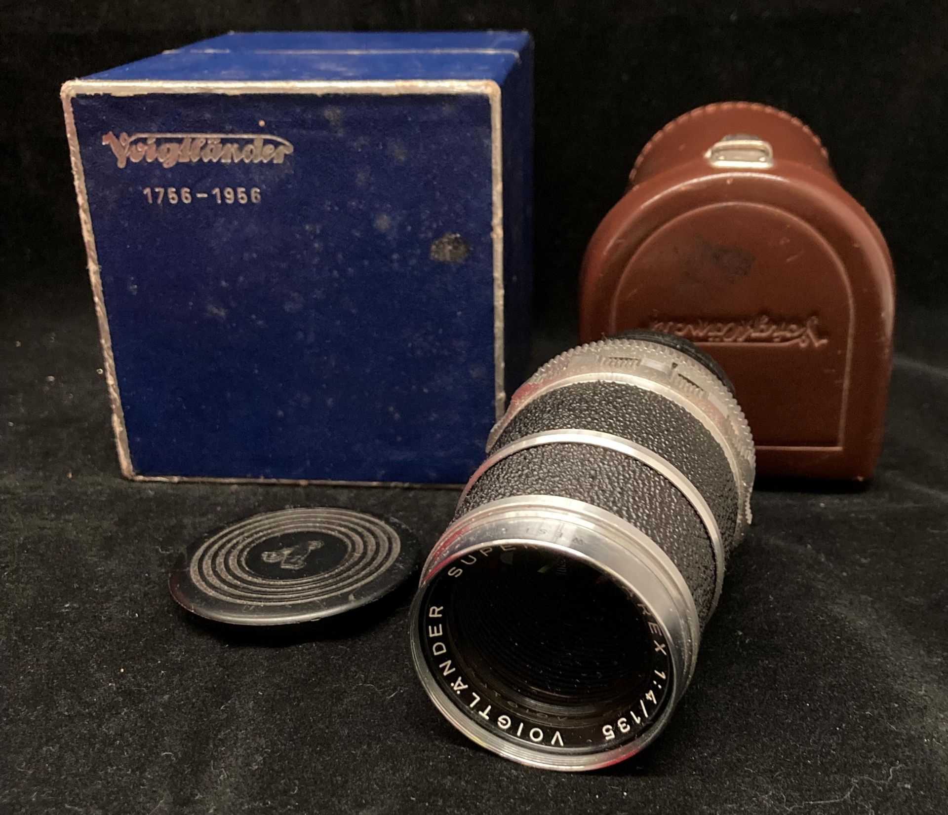 A Voigtlander Super-Dynarex 1:4/135 lens No: 5057836 in brown leather case and a Voigtlander blue