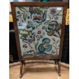 An oak framed folding fire screen/table with embroidered panel 53cm x 44cm