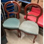 A pair of mahogany finish reproduction balloon back dining chairs with green patterned seats.