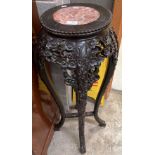 A Chinese peony carved hardwood jardiniere stand with an inset circular marble top 93cm high and