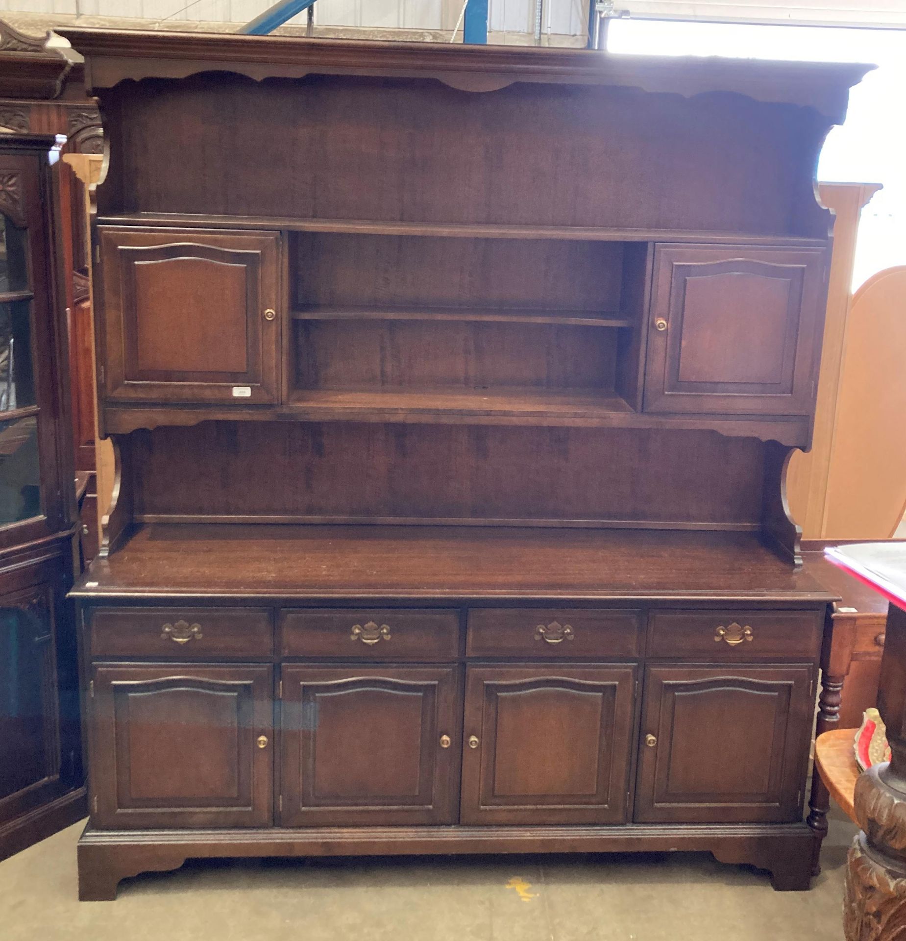 An oak wall unit with open shelf two door upper section over four door, four drawer base,