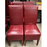 A set of four red leather effect high back dining chairs.