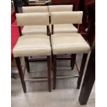 A set of four beige leather effect high bar stools - the upholstery is worn in places on all the