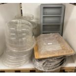 Contents to part of rack - assorted stainless steel serving plates, three plastic cutlery trays,