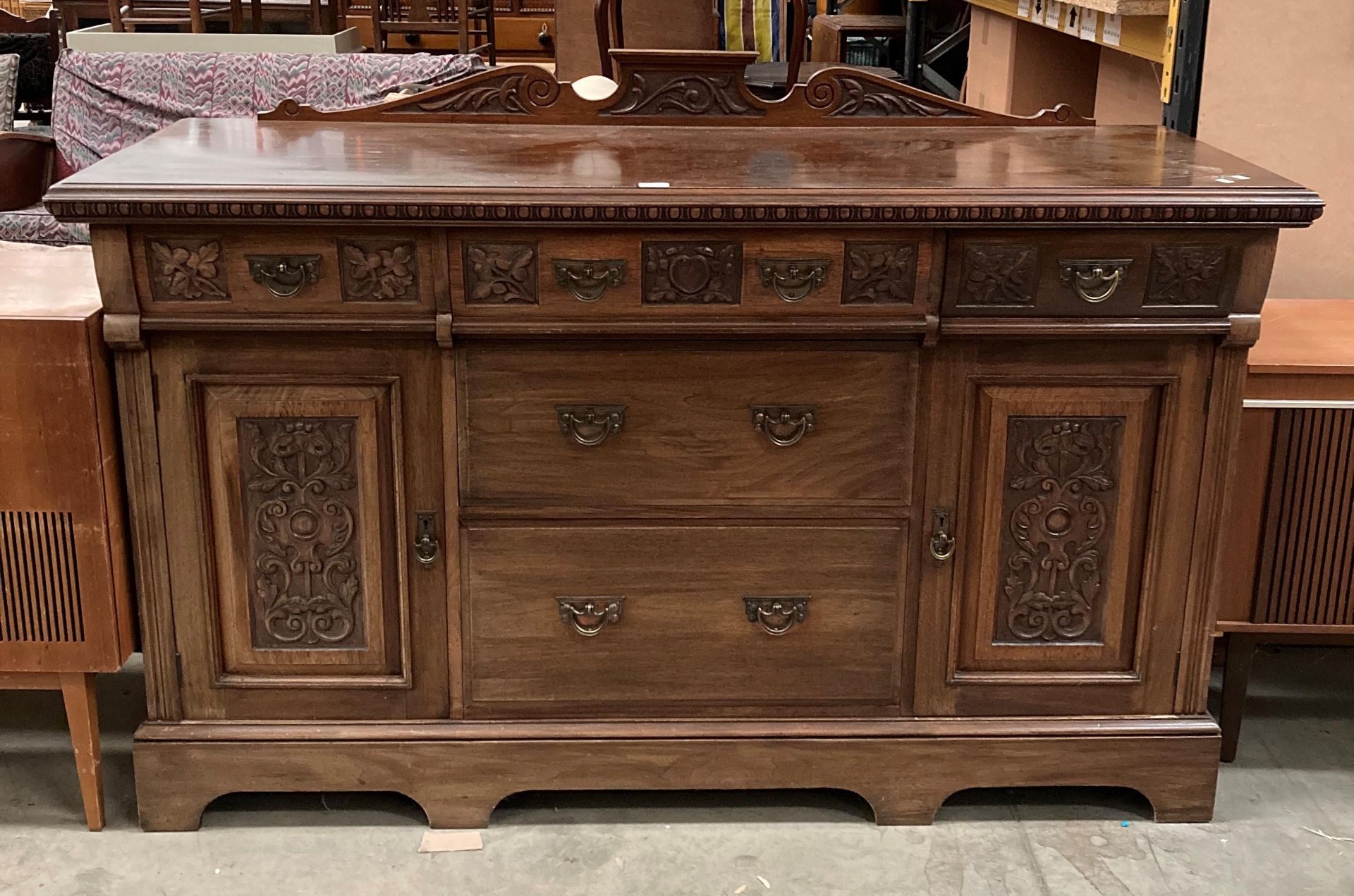 A late 19th century carved mahogany sideboard with five drawers and two cupboards,