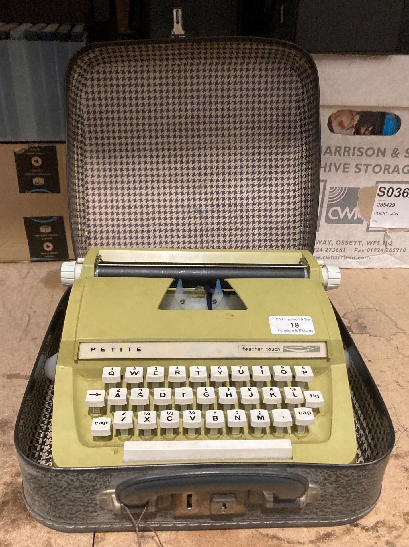 A Petite Feather Touch portable typewriter in case