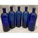 A set of five blue glass chemist's bottles numbered one to five, each 20cm high.