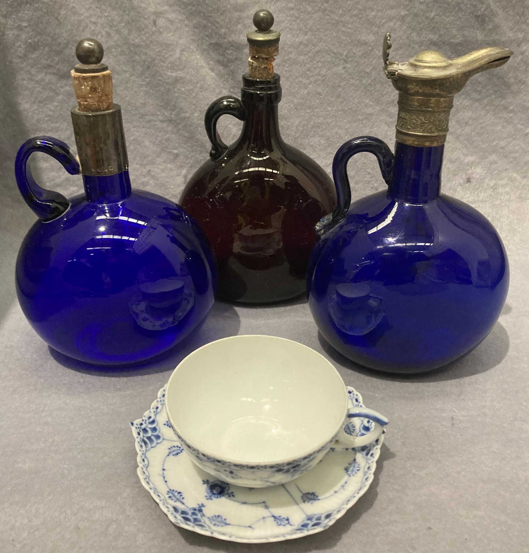 A blue glass decanter with metal top, handle chipped and repaired,
