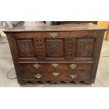 An oak kist with carved three panel front over two drawers, lettered to either side of lock FA1741,