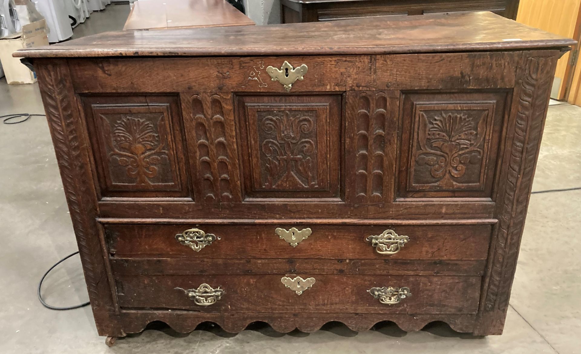 An oak kist with carved three panel front over two drawers, lettered to either side of lock FA1741,