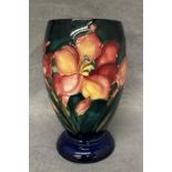 A Moorcroft ovoid pottery blue and green ground floral vase, 18.