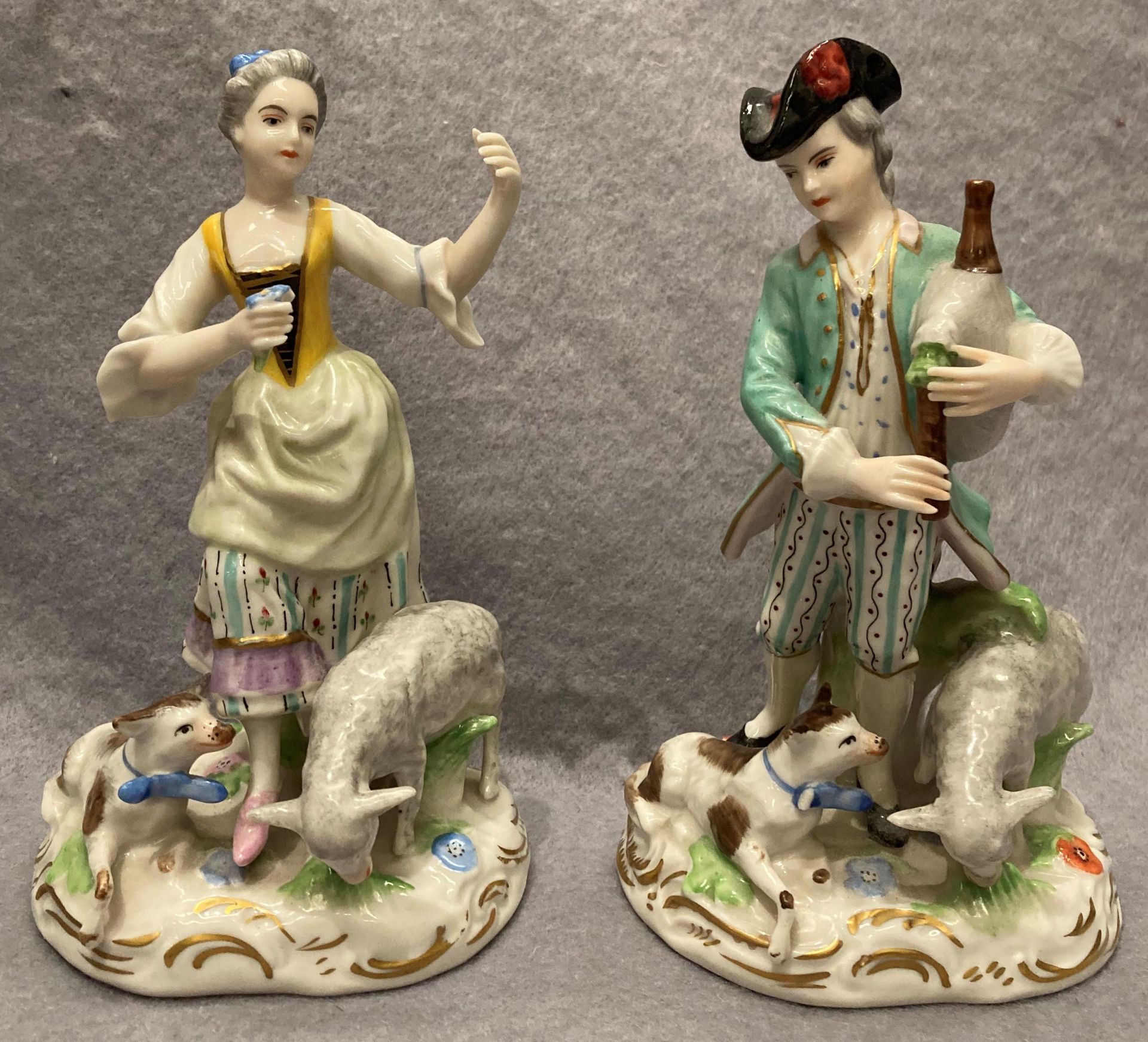 Pair of porcelain figurines, man and woman with animals, damage to the man's animal with bow,