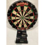 A Winmau Blade III dartboard with a set of darts.